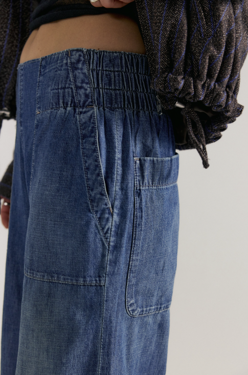 Close up of medium wash denim jeans on plain background