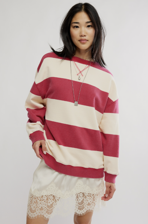 Woman wearing red and cream stripe top and lace skirt on plain background