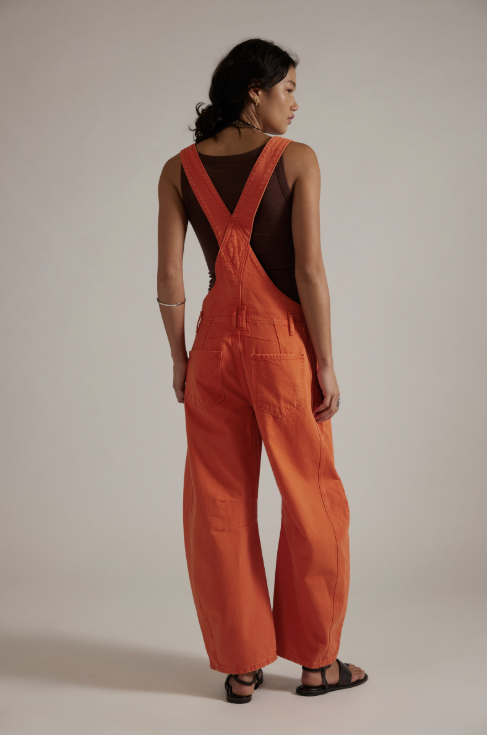 Person wearing an orange jumpsuit with a plain background