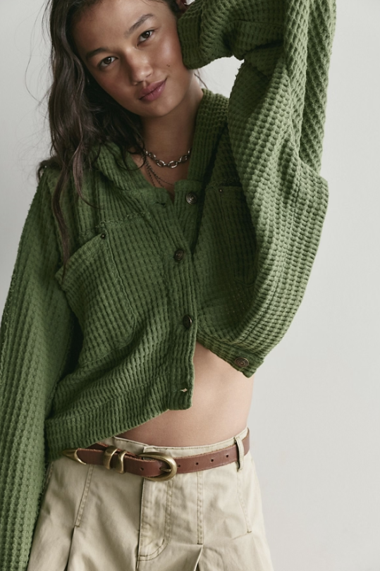 Woman wearing green cardigan on white background