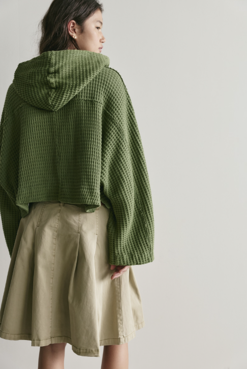 Woman wearing green cardigan on white background