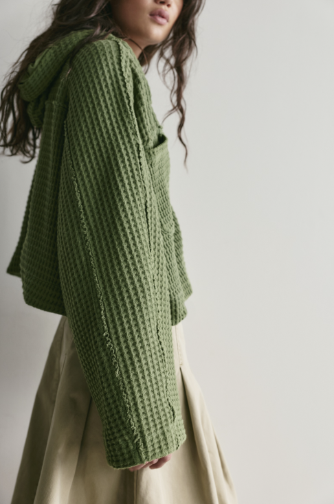 Woman wearing green cardi on white background