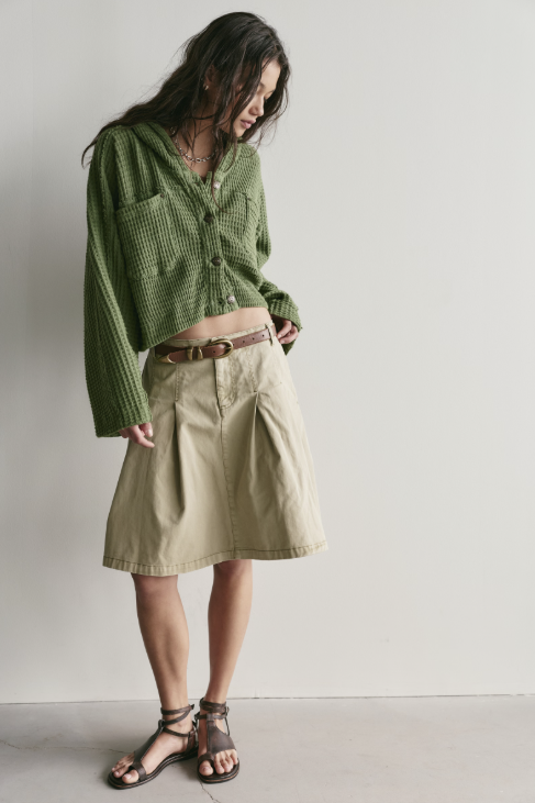 Woman wearing green cardigan on white background