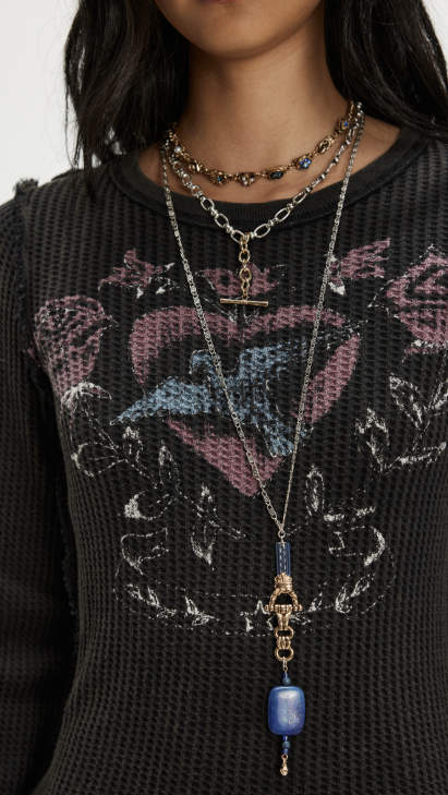 Close up of woman wearing black graphic long sleeve tee on plain background