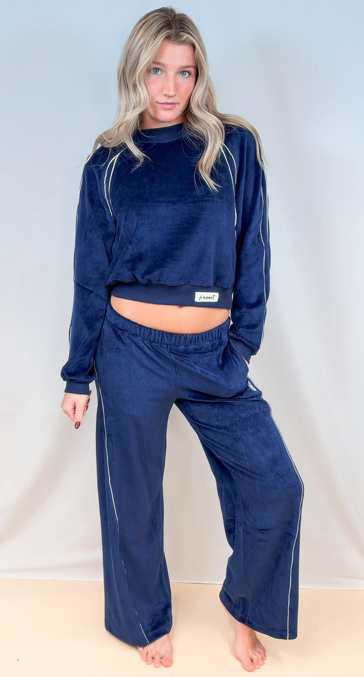 Woman wearing matching blue velour set with &