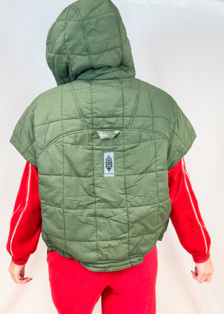 Woman shown from back view wearing matching red velour set with olive green puffy quilted vest on plain background