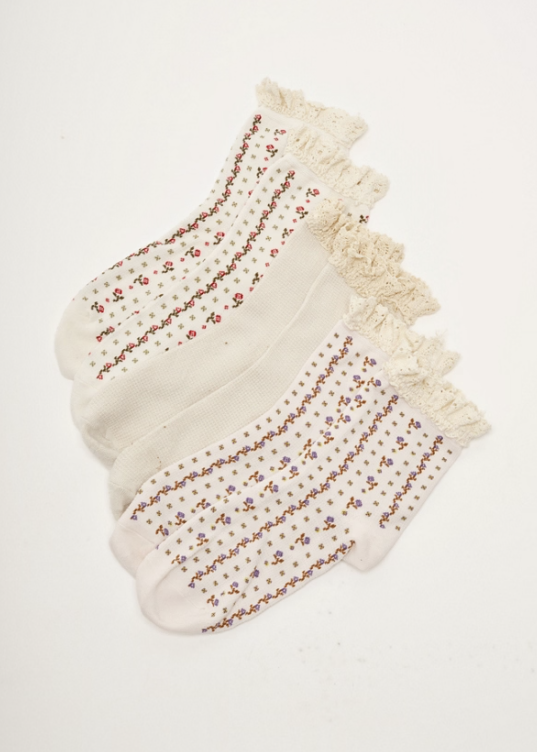 3 pairs of floral ruffle, ankle length ruffle socks on plain background