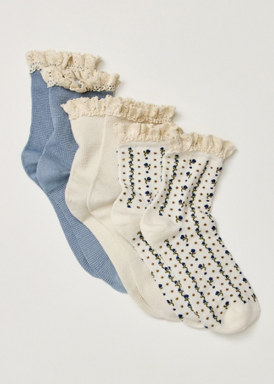 Set of 3 pairs of blue and floral ankle length ruffle socks on plain background