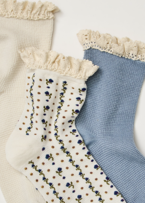 3 blue and floral ankle length ruffle socks on plain background