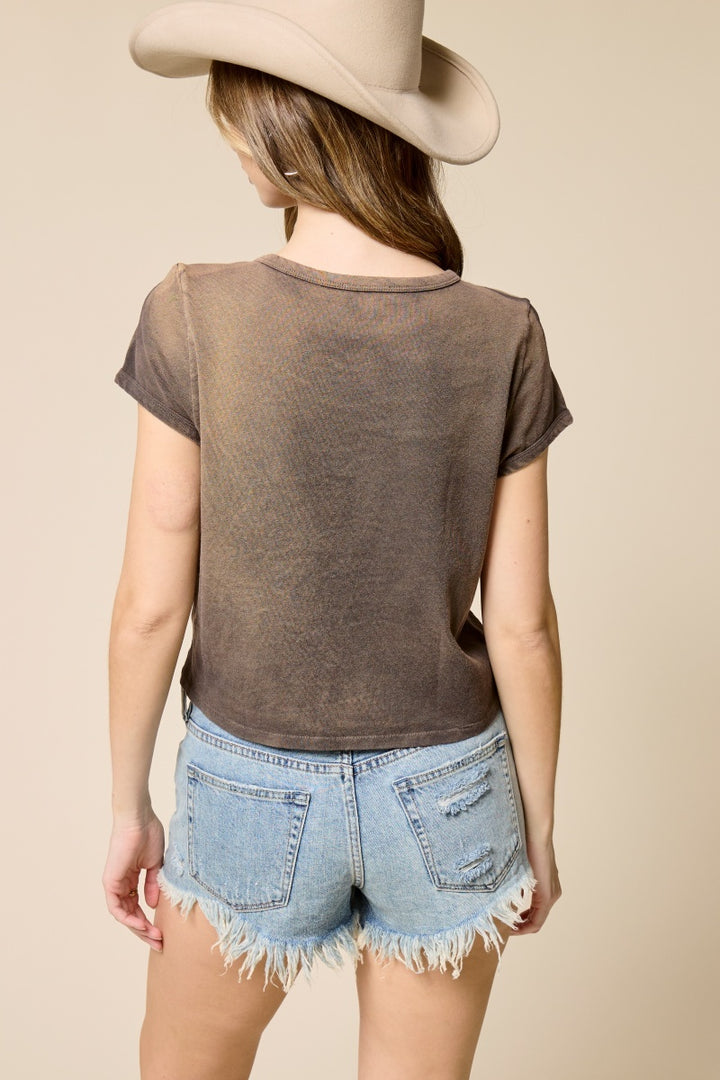 Woman wearing brown tshirt and denim shorts on plain background