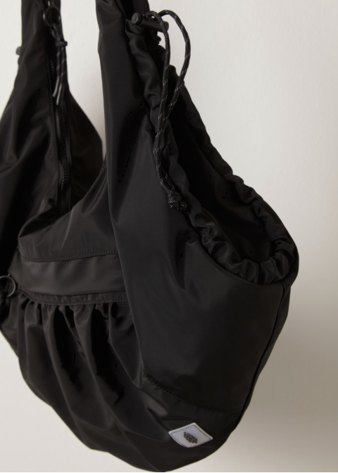 Black tote bag with logo patch on plain background