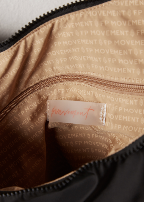 Close up of inside of tote bag with logo and writing on plain background
