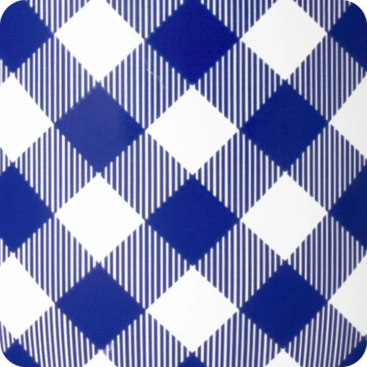 A close-up of a blue and white argyle patterned surface, likely a ceramic plate or coaster, with alternating solid blue and white diamonds and thin vertical stripe sections.