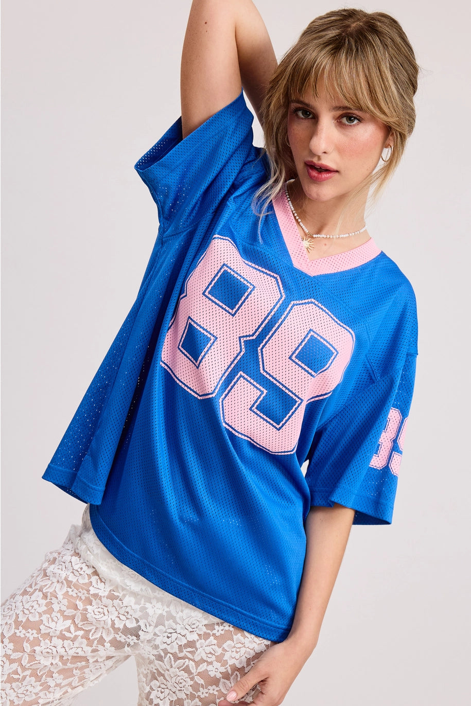 Woman wearing a blue oversized t-shirt with &