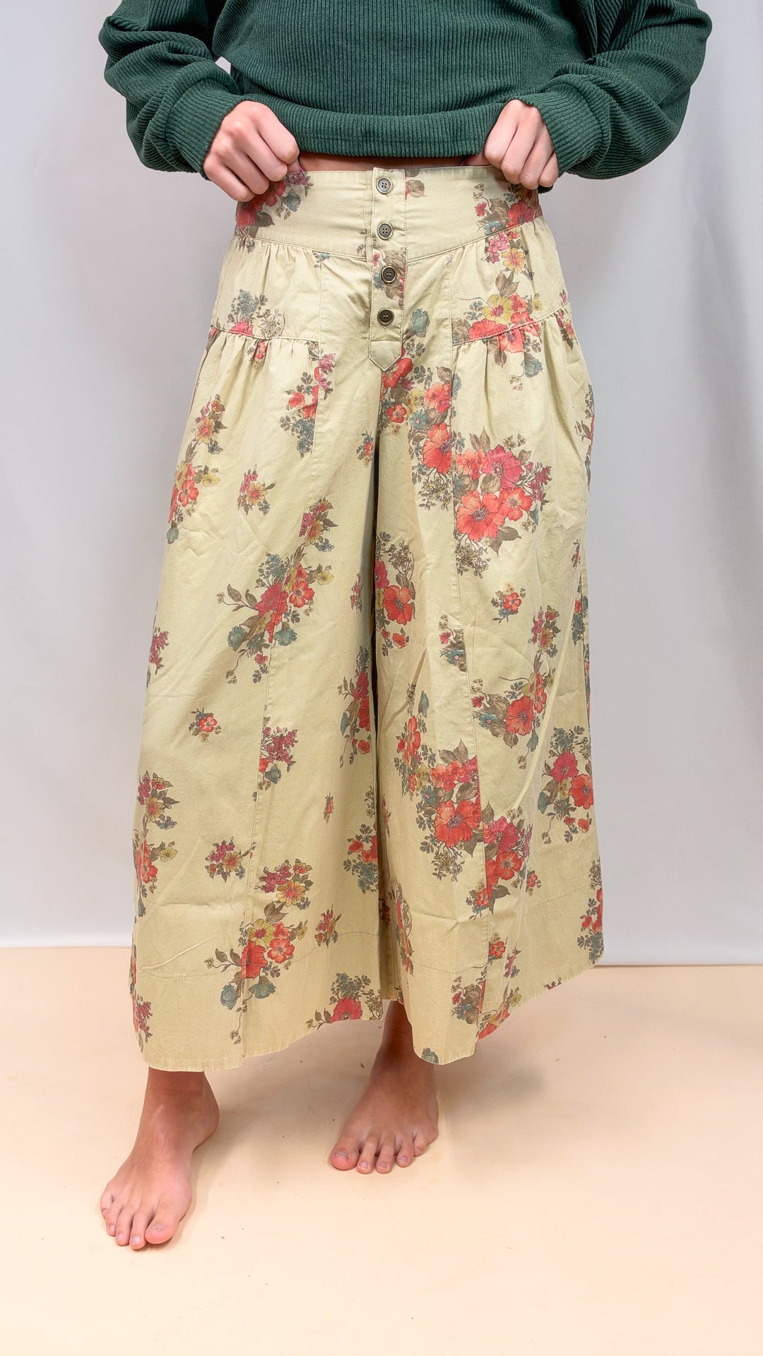 Woman wearing floral pants on plain background