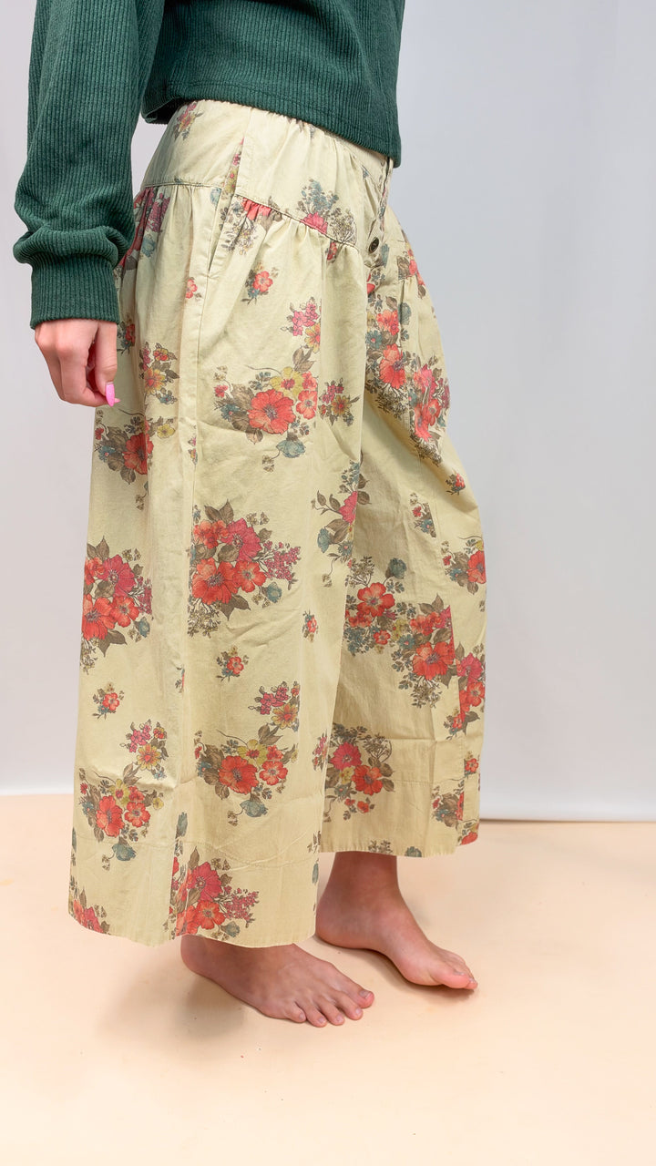 Woman wearing floral pants on plain background