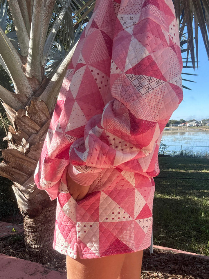 Person wearing pink quilted shorts and top standing outdoors