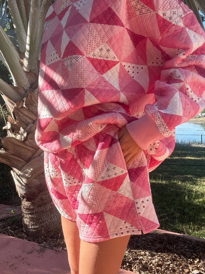 Person wearing pink quilted shorts and shirt standing outdoors