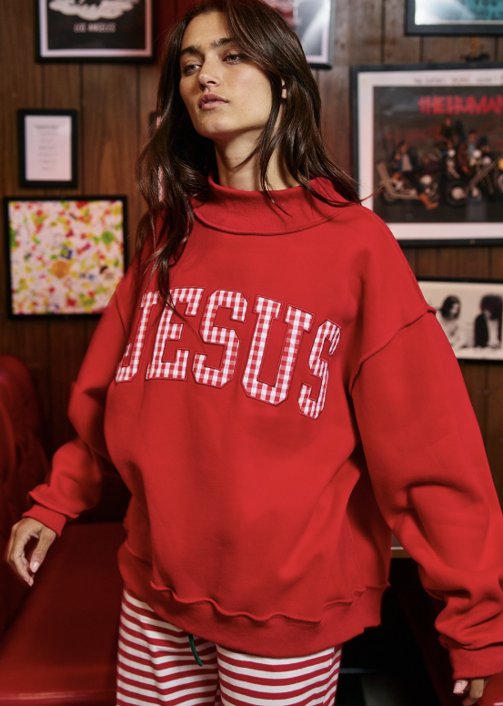 A woman wearing a red sweatshirt with &