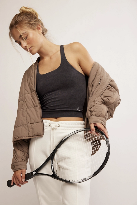 Woman holding a tennis racket against a plain background