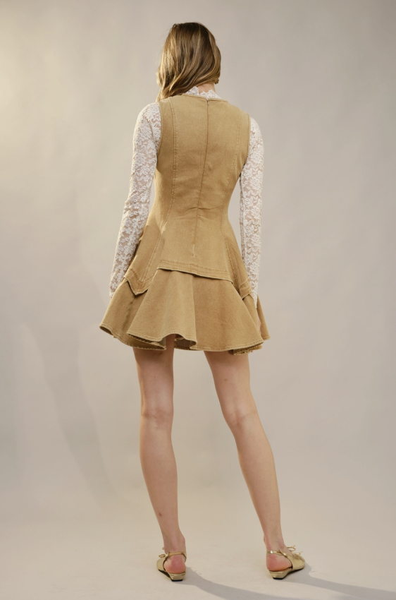 Person wearing a beige vest and skirt set on a plain background