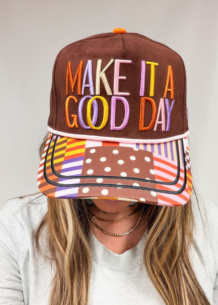 Person wearing brown faux suede hat with &