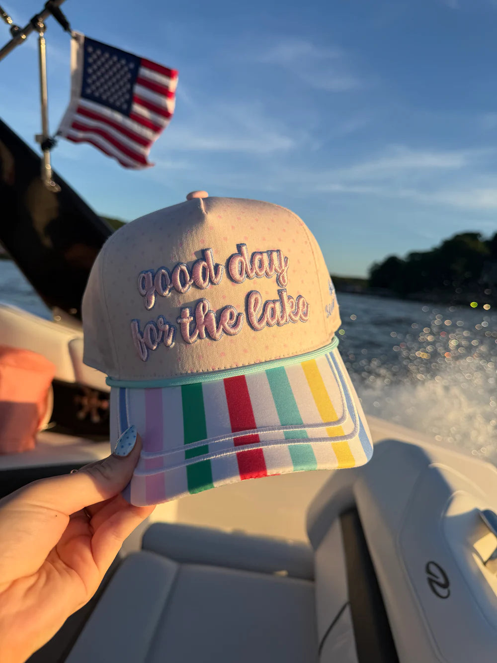 Hand holding hat embroidered with &