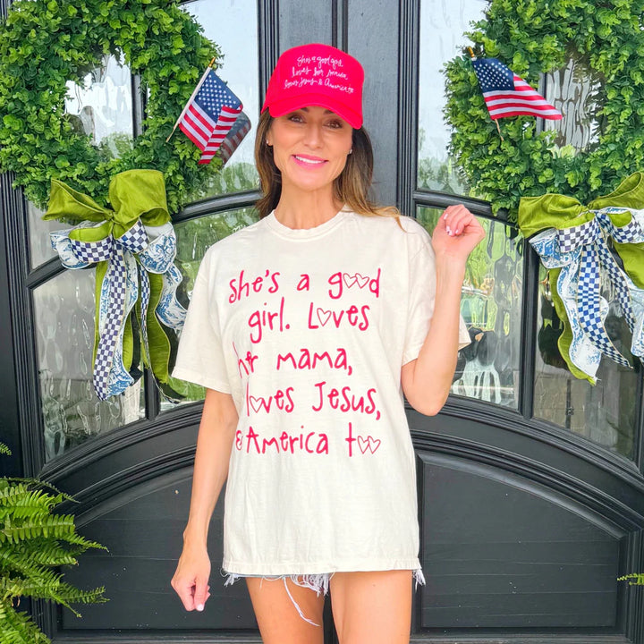 Woman wearing graphic tee and red hat standing outdoors