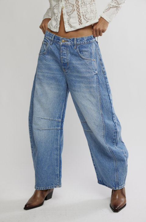 Person wearing blue jeans on a plain background