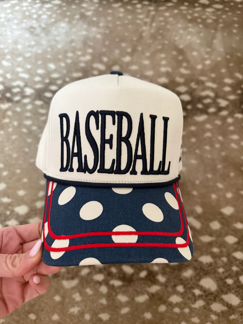 Trucker hat with 'BASEBALL' text and polka dot brim on patterend background