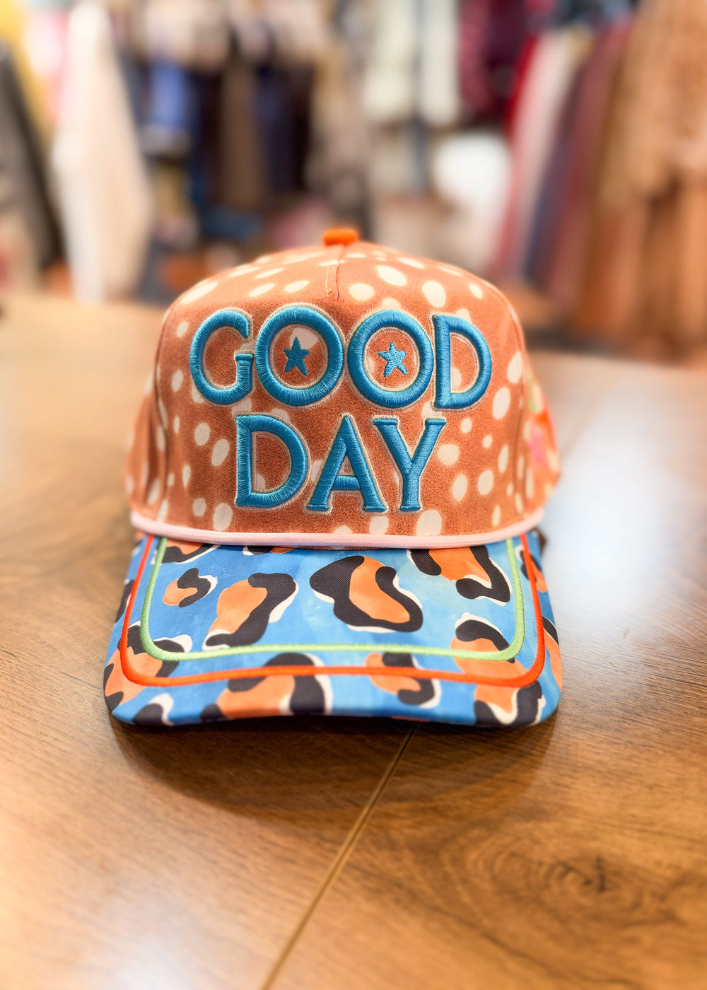 Fawn print hat with 'GOOD DAY' embroidered on front in blue with blue leopard bill 