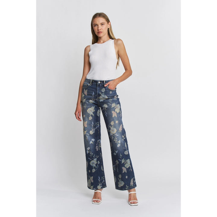 Woman wearing floral jeans and a white top on a white background