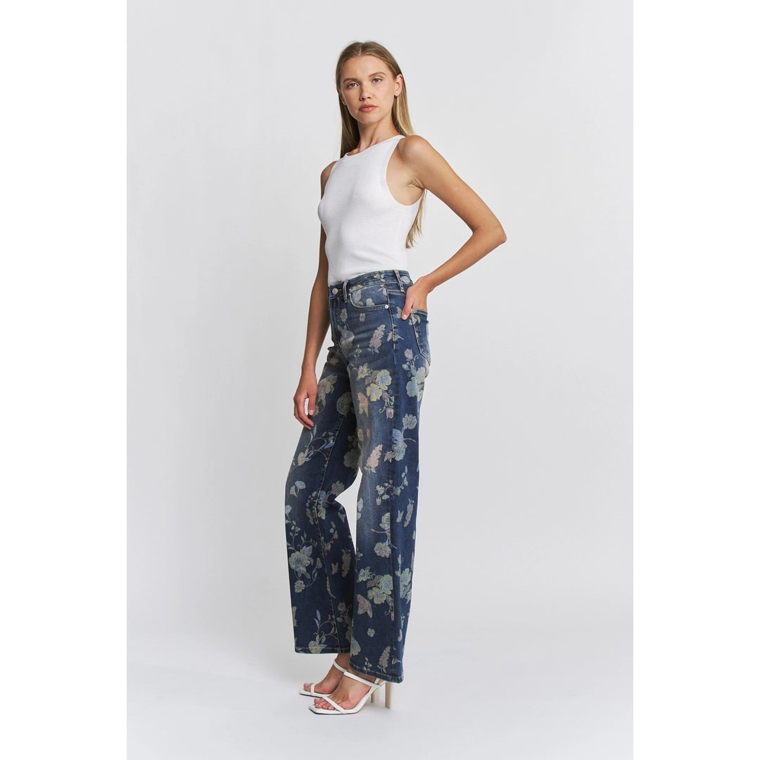 Woman wearing a white tank top and floral jeans on a white background