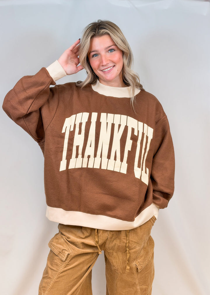 Woman wearing brown mock neck sweatshirt with cream &