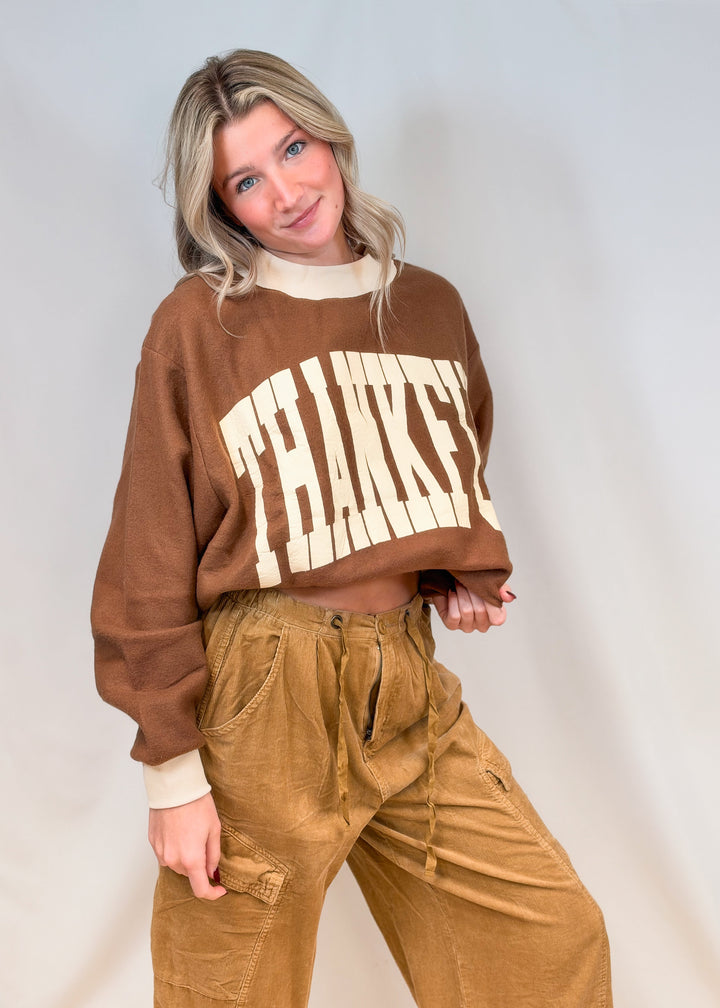 Woman wearing brown mock neck sweatshirt with beige &