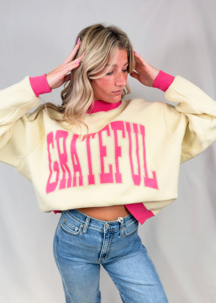 Woman wearing beige mock neck sweatshirt with &