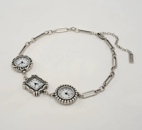 Silver paperclip style necklace with 3 clock faces on plain background