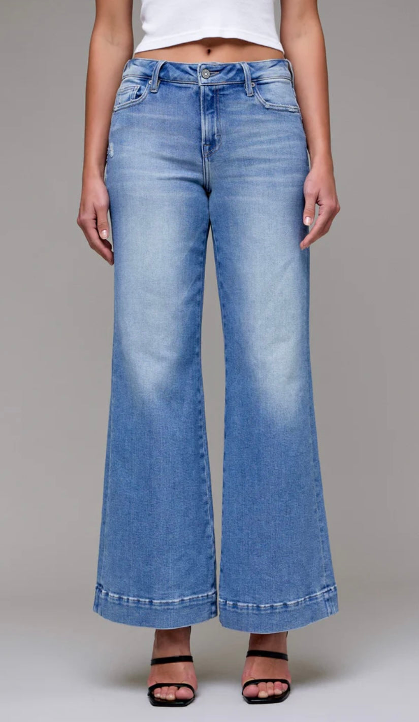 Light blue wide-leg jeans worn by a person on a gray background