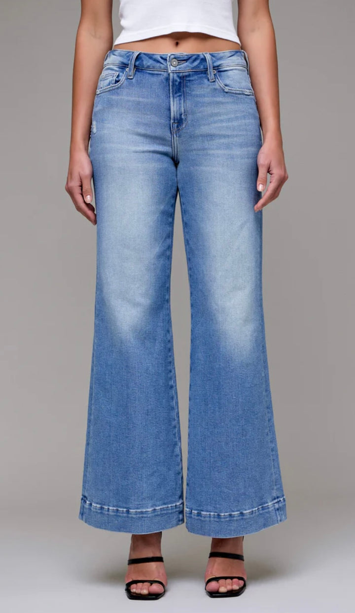 Light blue wide-leg jeans worn by a person on a gray background