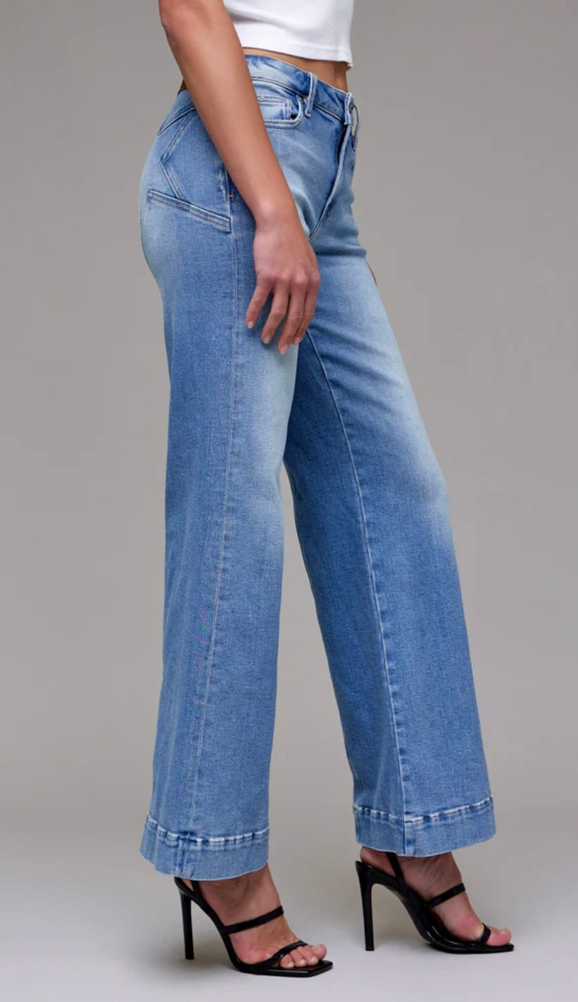 Person wearing blue jeans on a gray background