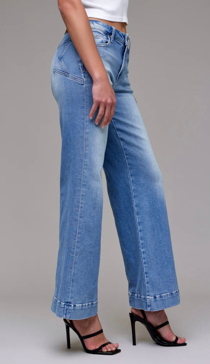 Person wearing blue jeans on a gray background
