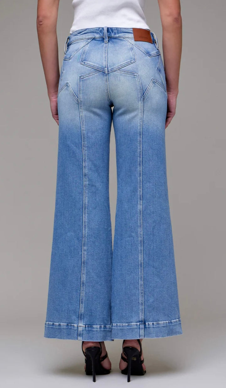 Woman wearing denim jeans in front of beige background