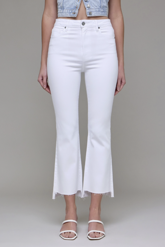 White flared jeans worn by a person on a plain background