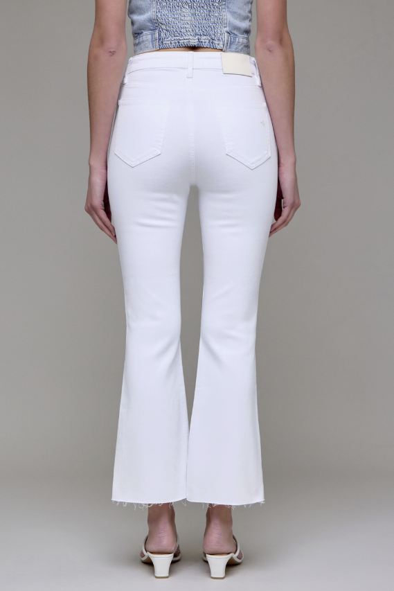 White flared jeans worn by a person on a plain background