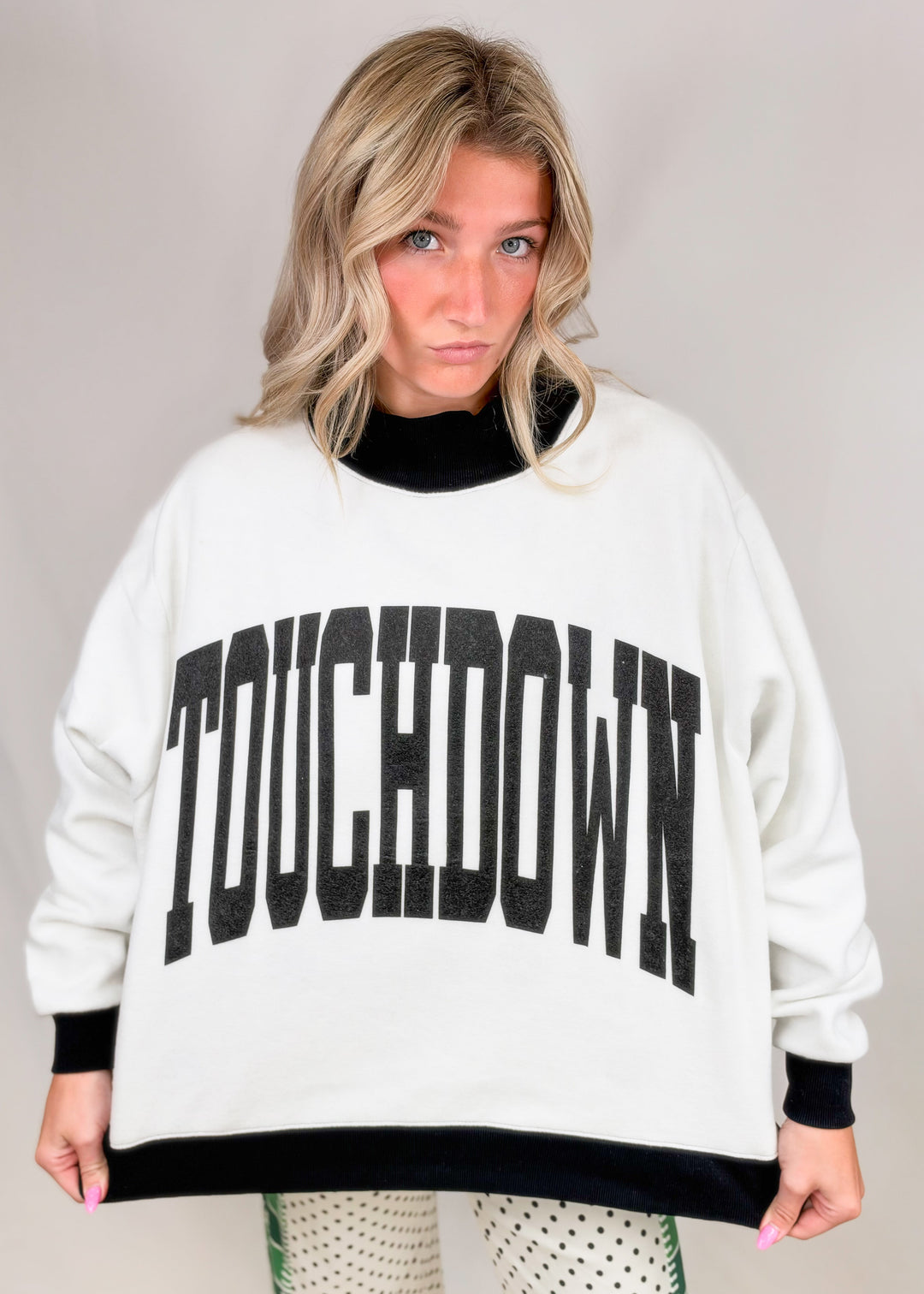 Woman wearing black and white mock neck with &