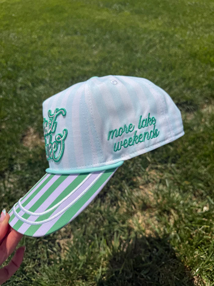 Light blue cap with green text and white stripes on a grass background