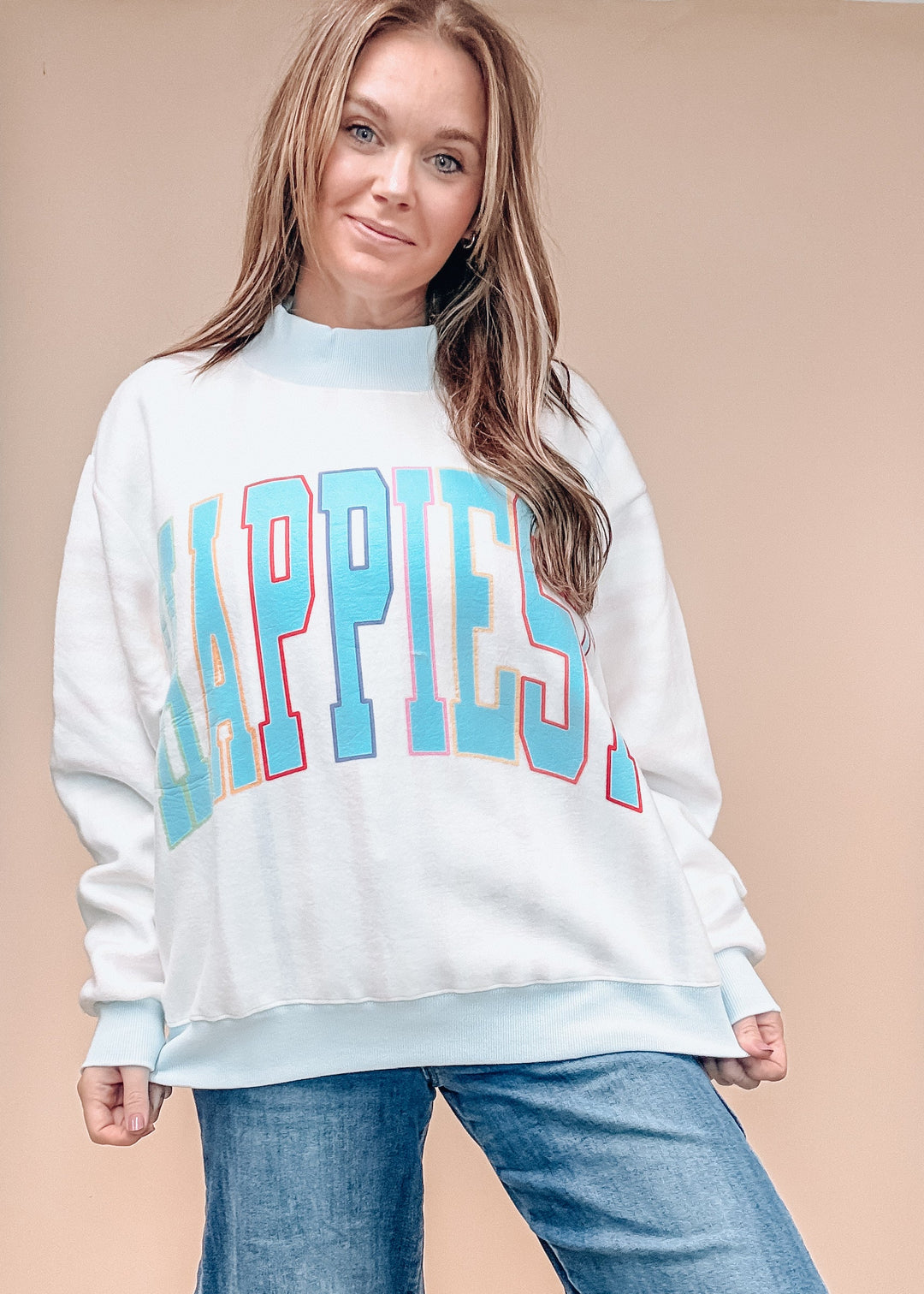 A woman modeling a white crewneck sweatshirt with &