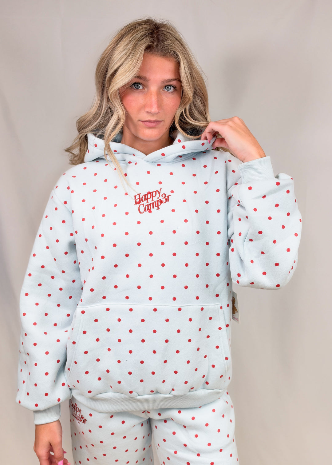 Woman wearing blue sweatshirt with red polka dots and &