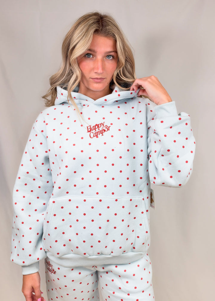 Woman wearing blue sweatshirt with red polka dots and &