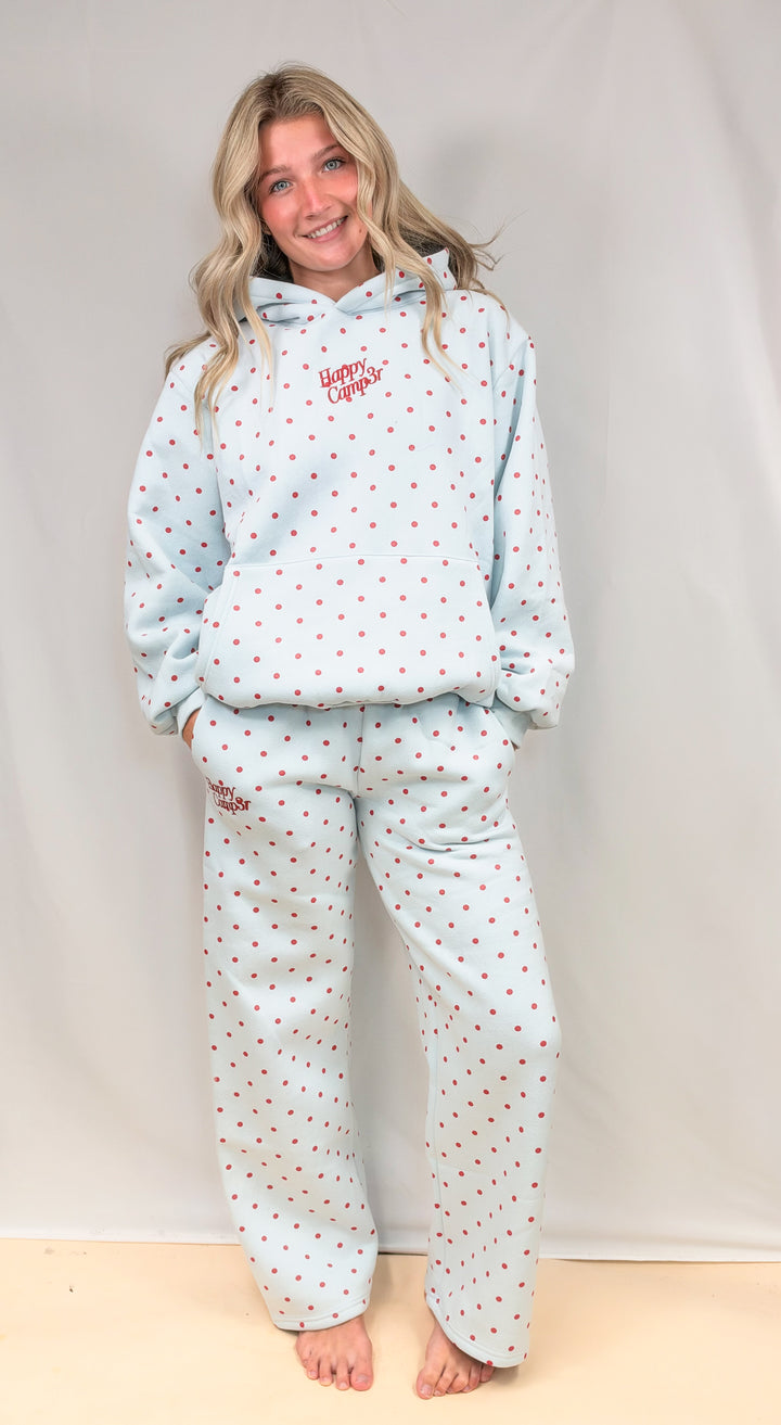 Woman wearing blue matching sweatshirt and sweatpants with red polka dots and &